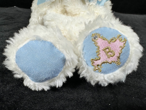 くまくみゃリュックの足の裏のアップ写真。ピンク色の生地にゴールドでブランドの「B」のイニシャルが刺繍されているデザイン。