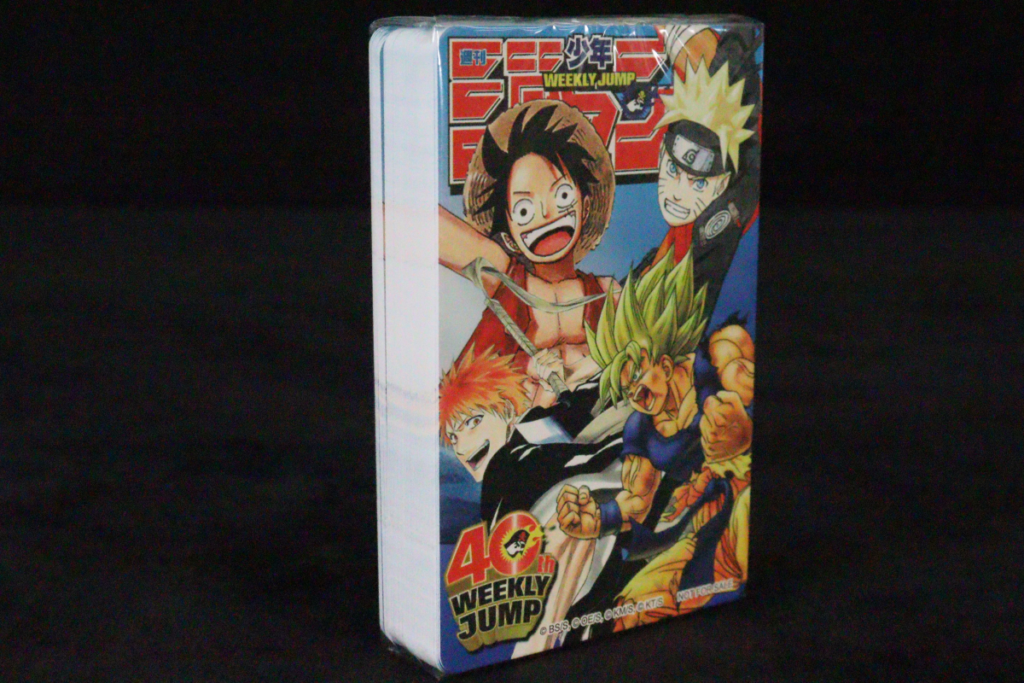 週刊少年ジャンプ創刊40周年記念グッズ「4大スター競演トランプ」のパッケージ。ルフィ、ナルト、悟空、両津勘吉が描かれた外箱。