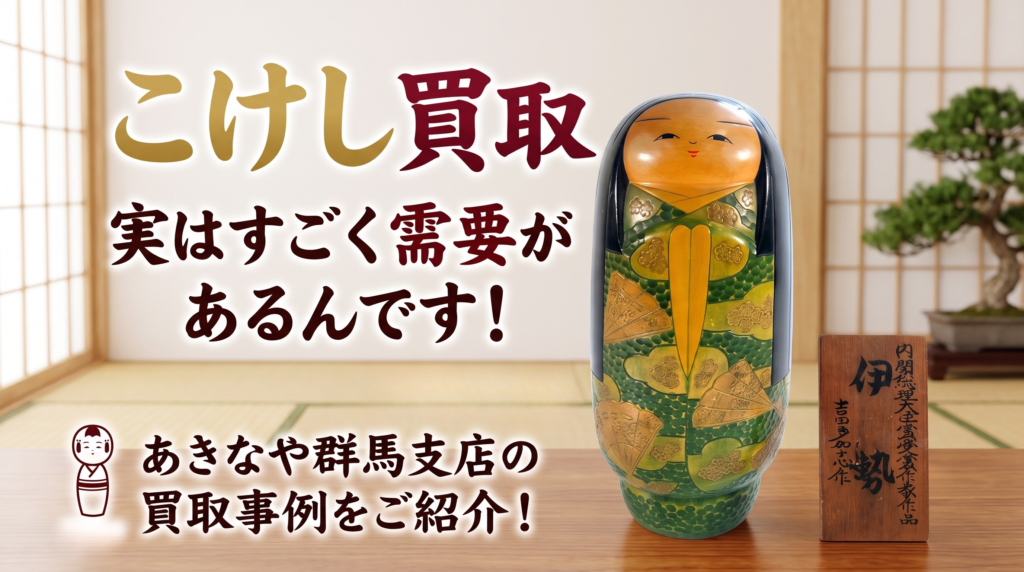 伝統的な和室を背景に、金と深紅の文字で「こけし買取」「あきなや群馬支店」と書かれたサムネイル。中央の座卓には、伊勢と吉田多加志による緑と金の扇模様の木目込みこけしと、その銘板2枚、茶器、扇子が並べられている。下部には「一点一点を丁寧に査定させていただきます」とあり